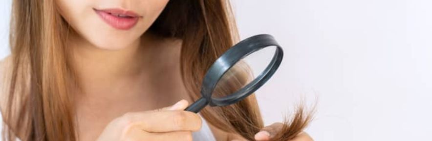 femme qui regarde ses pointes à la loupe