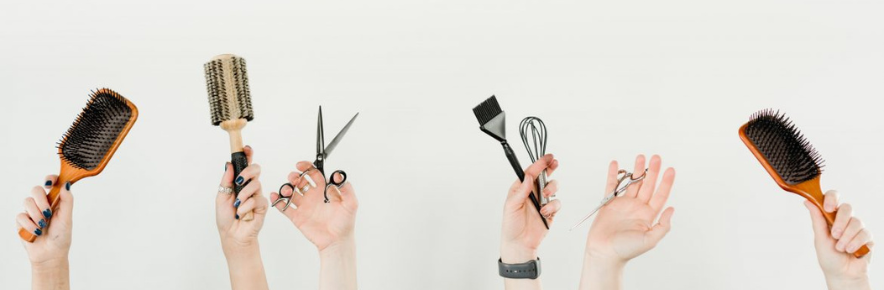 mains qui portent brosse peigne et paire de ciseaux