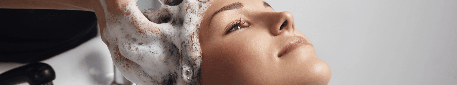 coiffeur qui applique un shampoing post coloration à sa cliente