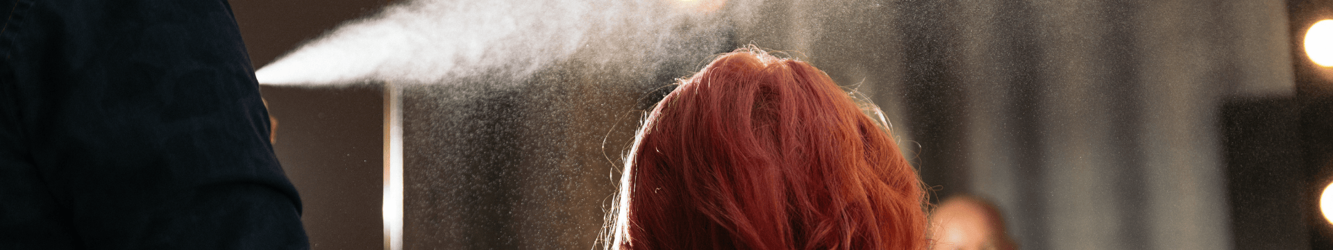 laque appliquée sur les cheveux rose d'une femme